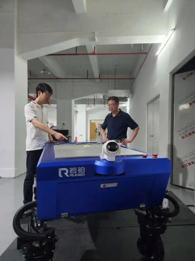 李兰云（右）和公司技术负责人罗东玮（左）探讨“机器牛”的技术问题。受访者供图